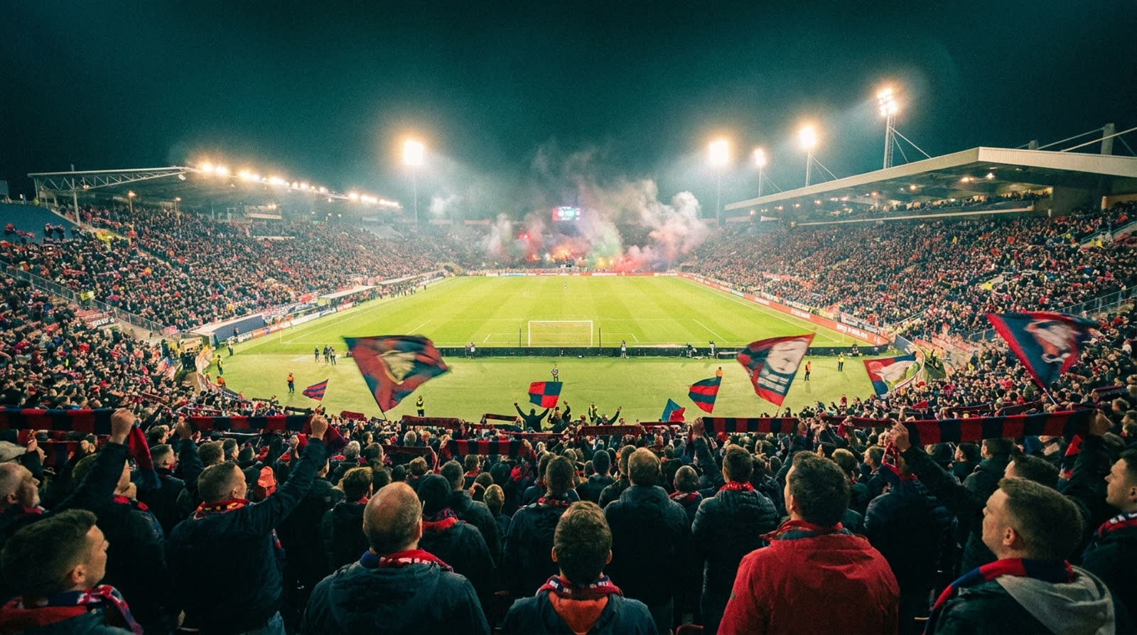 Flomlyst stadion i kveldsmørket, sett fra tribunen